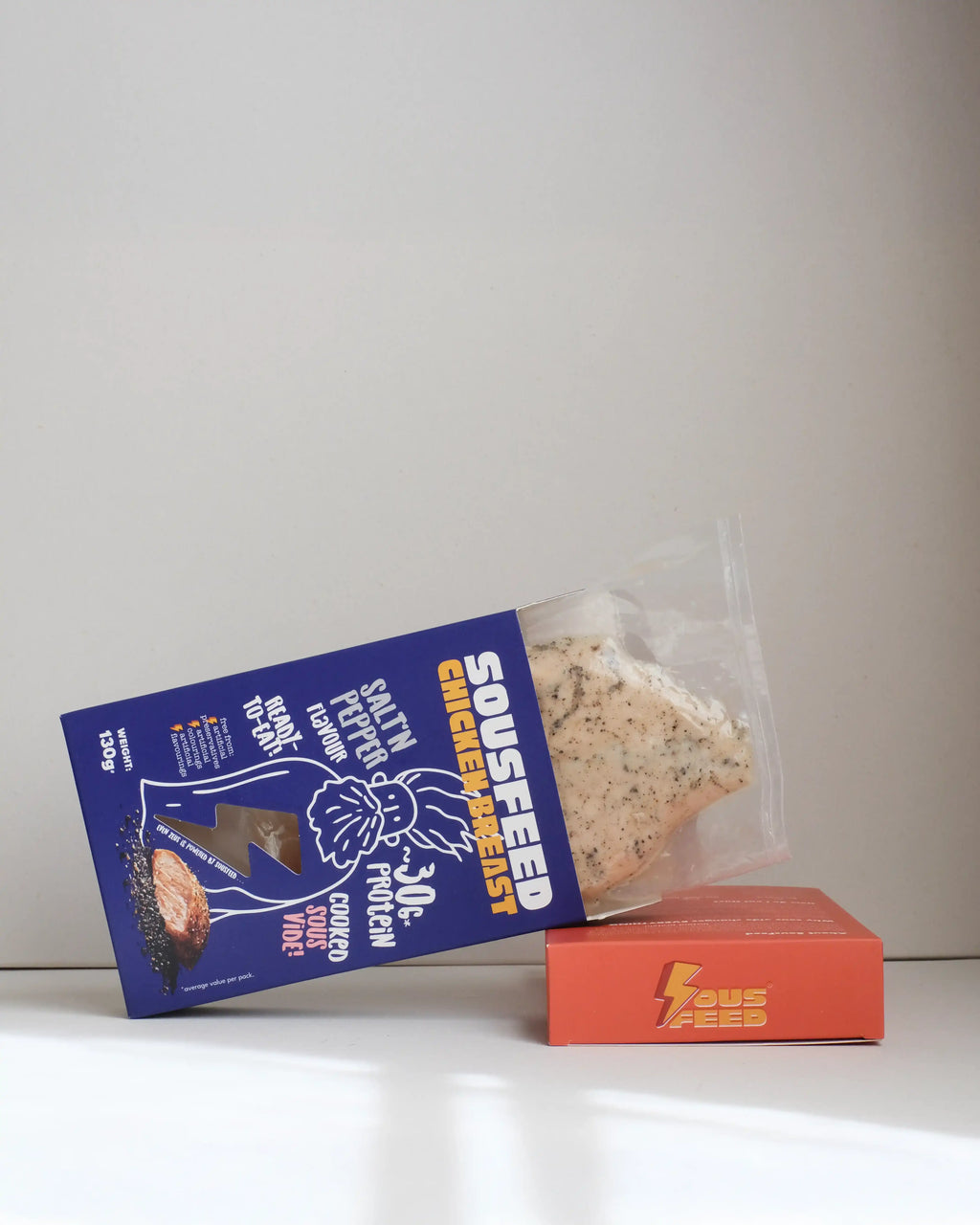 Sousfeed salt and pepper flavoured chicken breast with its packaging on a white background
