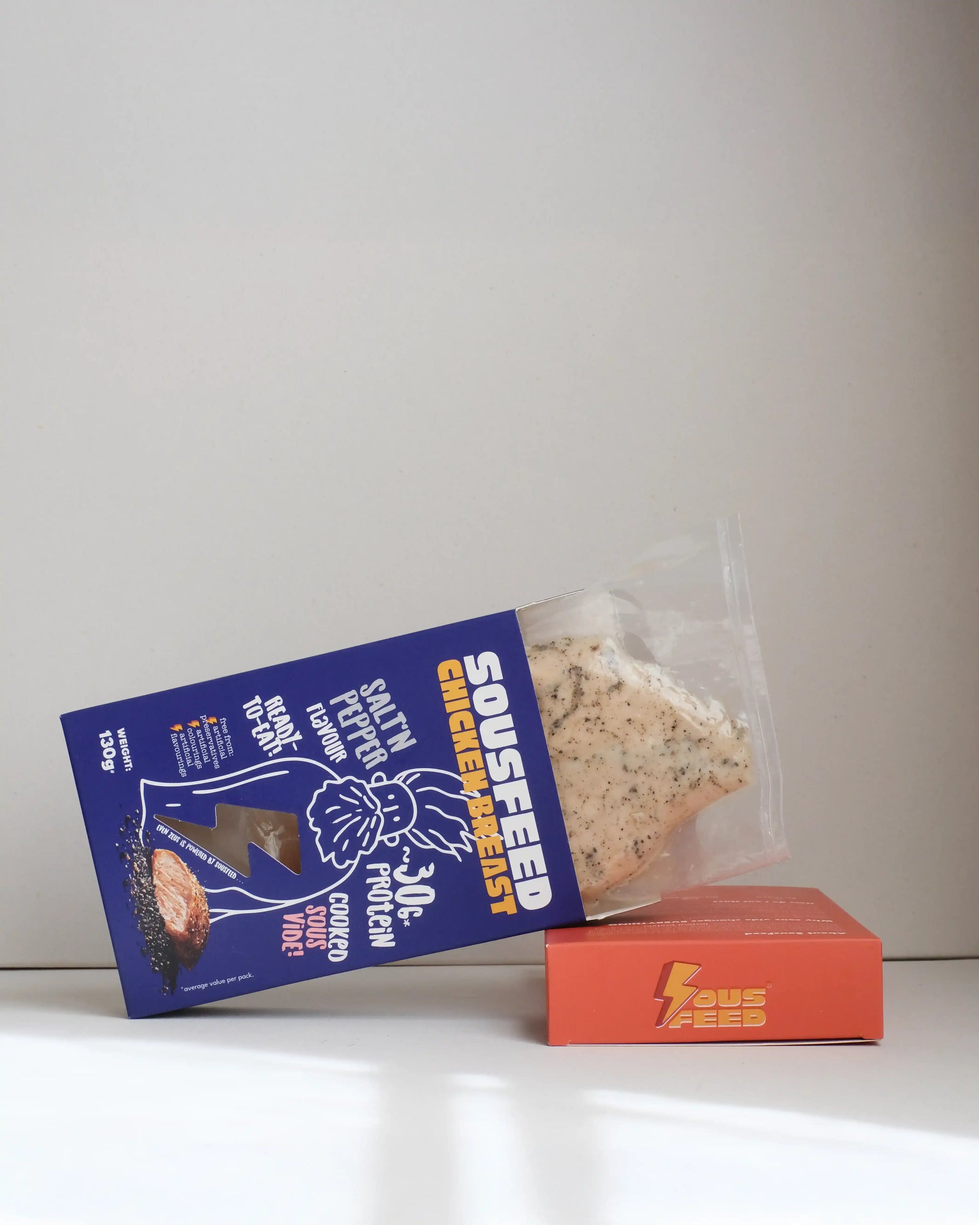 Sousfeed salt and pepper flavoured chicken breast with its packaging on a white background
