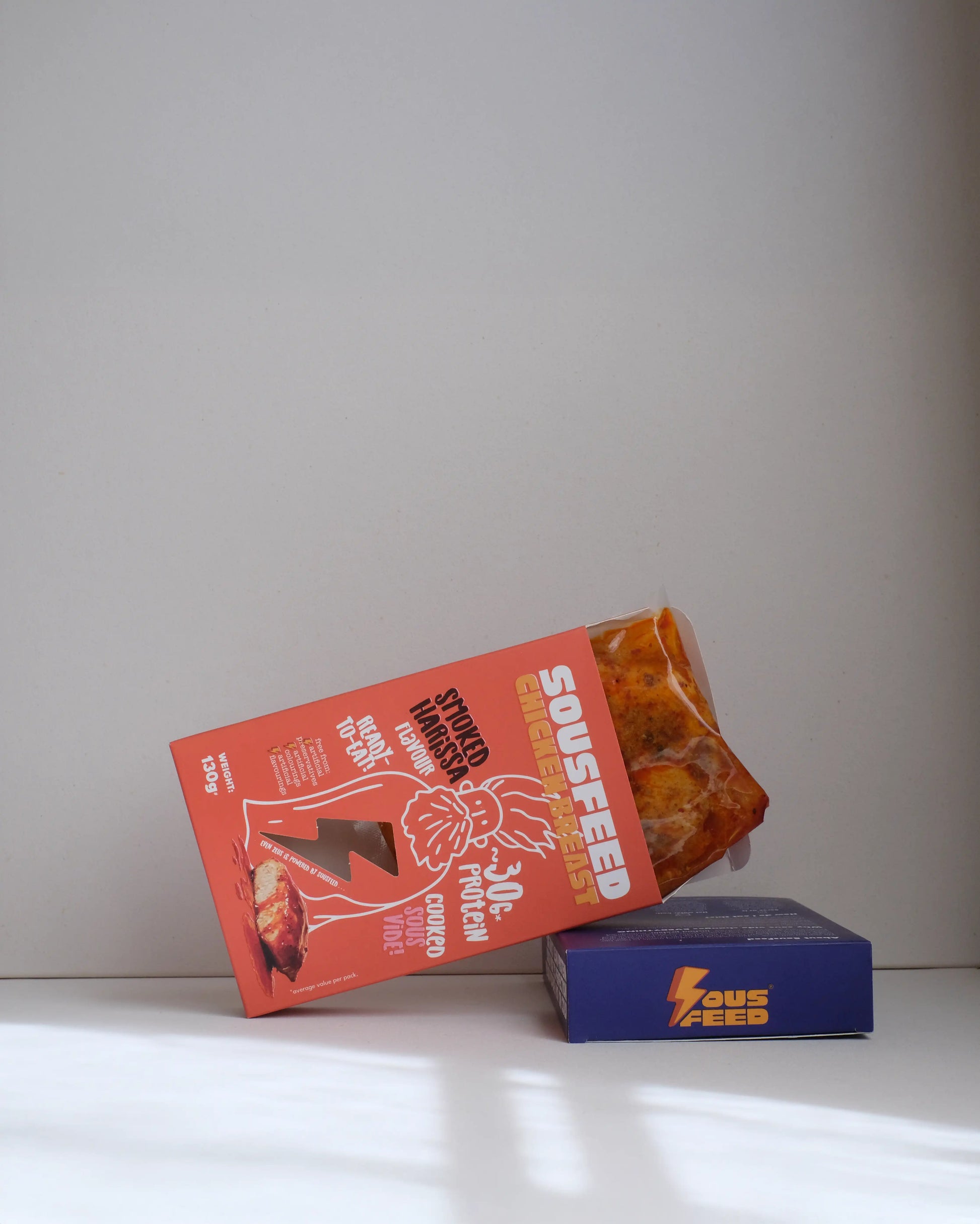 Sousfeed smoked harissa flavoured chicken breast with its packaging on a white background