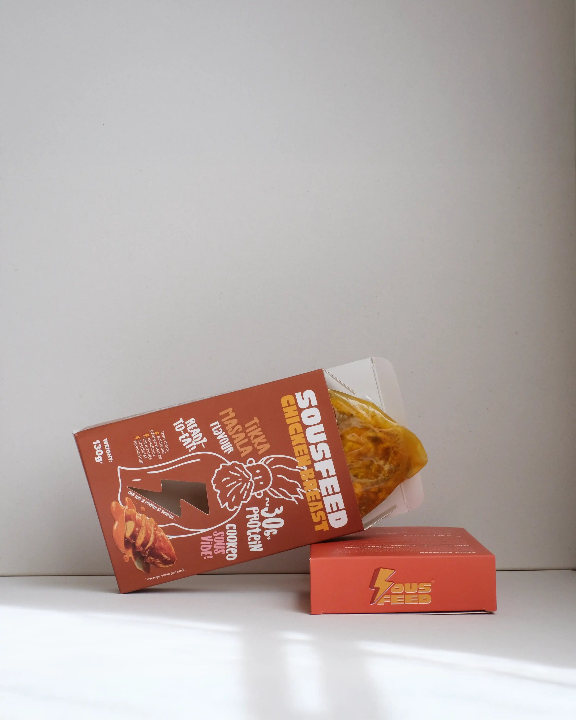 Sousfeed tikka masala flavoured chicken breast with its packaging on a white background