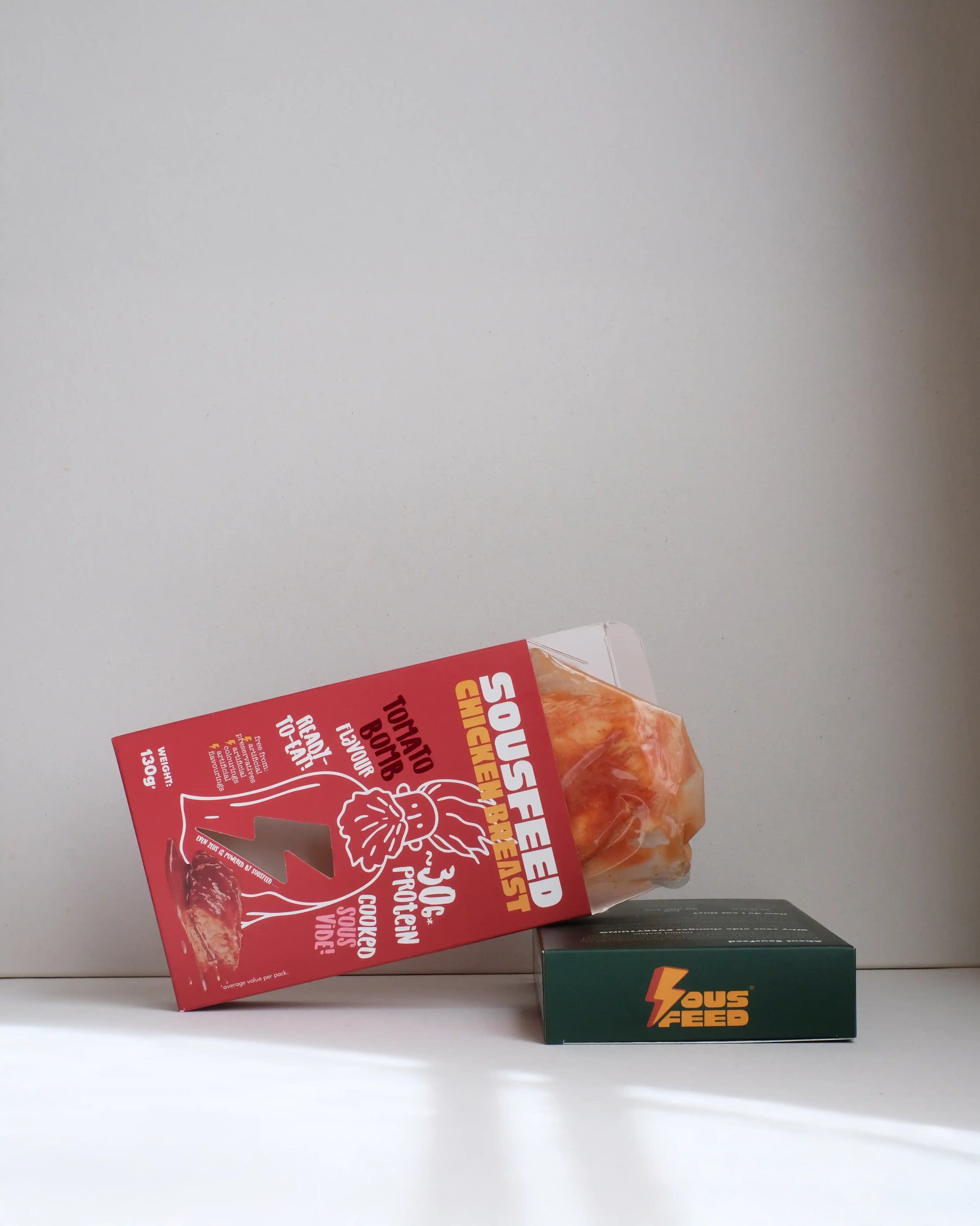 Sousfeed tomato bomb flavoured chicken breast with its packaging on a white background