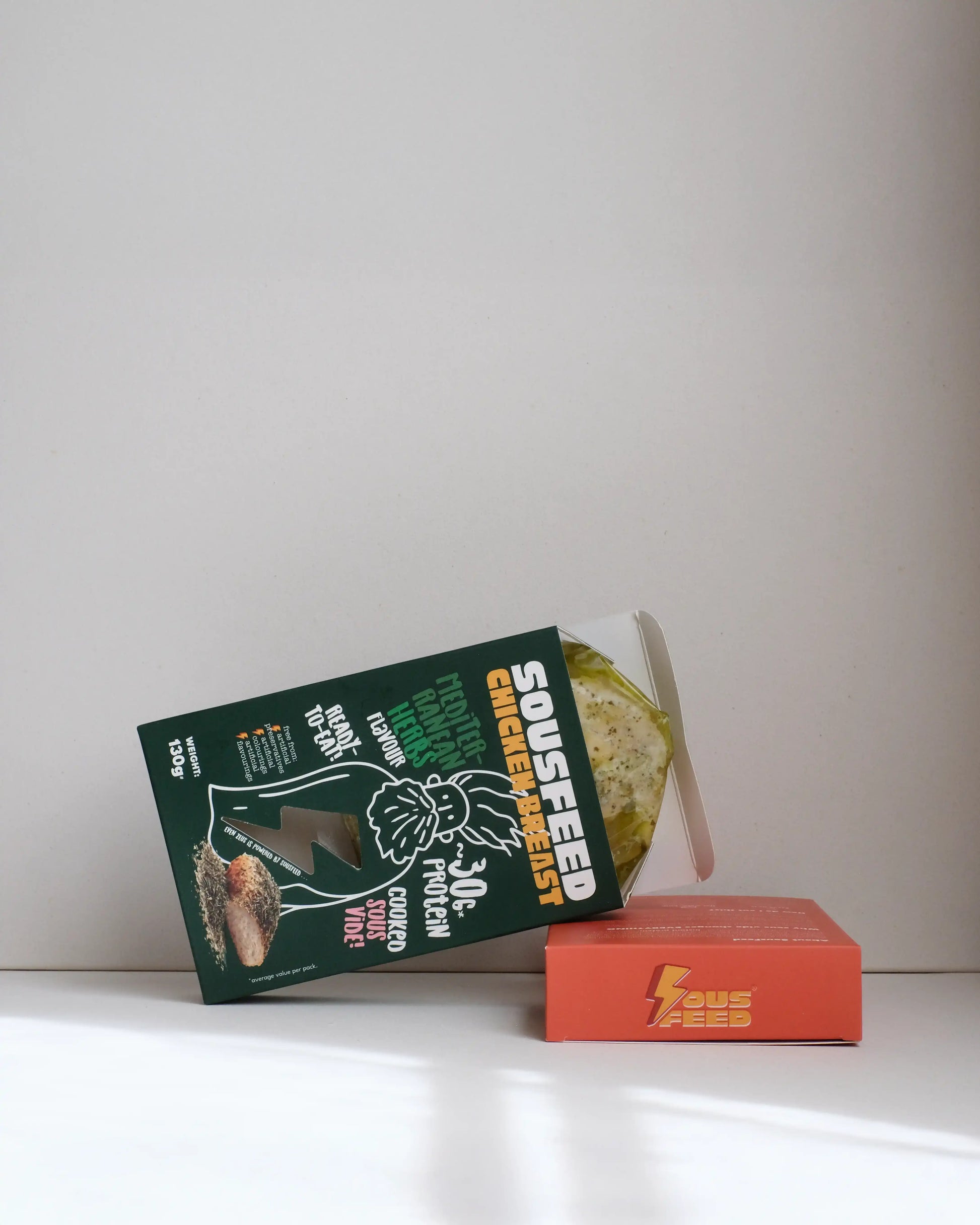 Sousfeed mediterranean herbs flavoured chicken breast with its packaging on a white background
